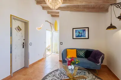 a living room with a blue couch and a table at Casa tempo e amor in Vila do Bispo