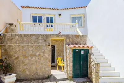 a house with a staircase and a green door at Casa tempo e amor in Vila do Bispo
