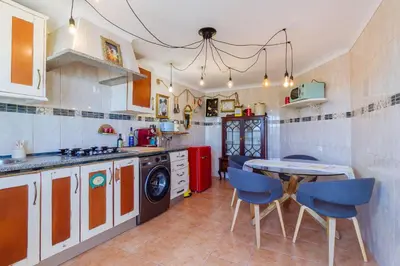 a kitchen with a table and blue chairs at Casa tempo e amor in Vila do Bispo