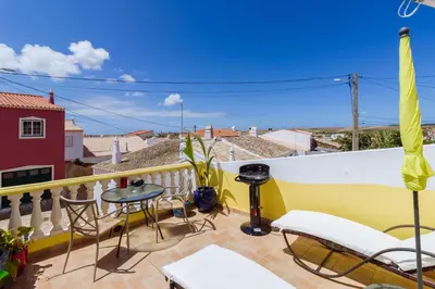 a balcony with chairs and a table and a view at Casa tempo e amor in Vila do Bispo