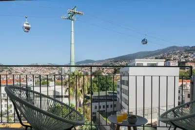 a view of a city from a balcony with chairs at Apartamento Jaime Moniz by An Island Apart in Funchal