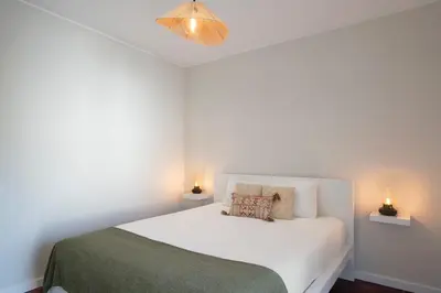 a bedroom with a white bed with two lights on it at Apartamento Jaime Moniz by An Island Apart in Funchal