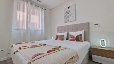 a white bedroom with a large bed with pink pillows at Carmo City Palace by LovelyStay in Funchal