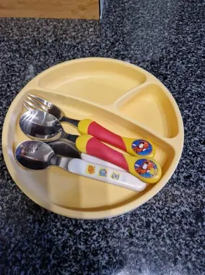a yellow plate with utensils on a table at House in Camara de Lobos in Estreito de Câmara de Lobos