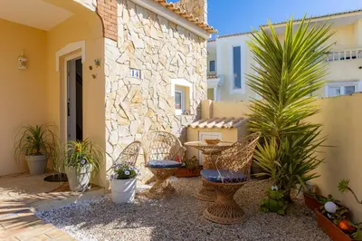 a house behind a stone wall with a gate at Villa Arpeggio - Cozy 3-Bedroom Villa with Private Pool in Montinhos da Luz, Lagos in Mato Porcas