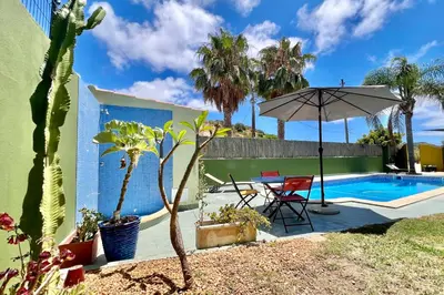 a patio with a table and an umbrella next to a pool at Private renovated APT w pool, 3m to praia da Luz in Valverde