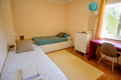 a bedroom with two beds and a desk and a window at Private renovated APT w pool, 3m to praia da Luz in Valverde