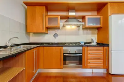 a kitchen with wooden cabinets and a white refrigerator at Refugio Dourado in Água de Pena