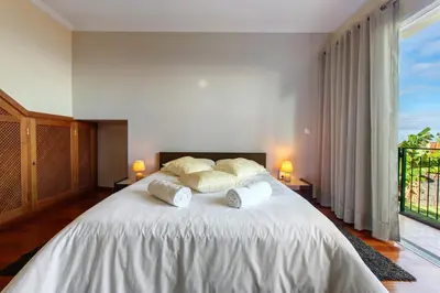 a bedroom with a large white bed with two pillows at Refugio Dourado in Água de Pena