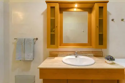 a bathroom with a sink and a mirror at Refugio Dourado in Água de Pena