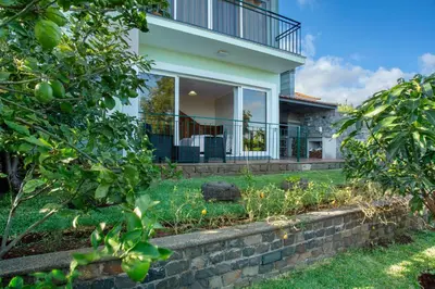 a house with a yard with a stone retaining wall at Refugio Dourado in Água de Pena