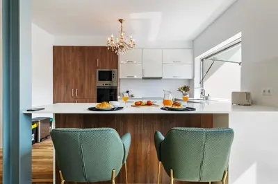 a kitchen with a white counter and chairs at Diogo House - view Funchal in Funchal