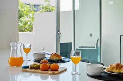 a table with two glasses of orange juice and croissants at Diogo House - view Funchal in Funchal