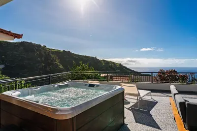 a hot tub on the balcony of a house at Casa de Pedra by An Island Apart in Ribeira Brava
