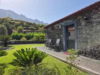 a stone house with a garden and a patio at Casa da Marica in São Vicente
