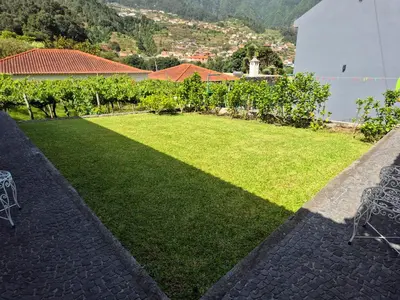 a patio with chairs and a lawn with a view at Casa da Marica in São Vicente