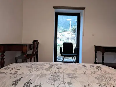 a bathroom with a toilet and a sink and a mirror at Casa da Marica in São Vicente