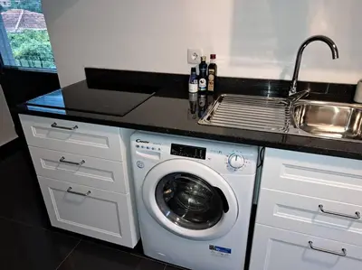 a kitchen with a sink and a washing machine at Casa da Vicencia in São Vicente