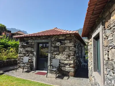 a stone wall in front of a house at Casa da Vicencia in São Vicente