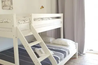 a white bunk bed in a small room at 3 bedroom Beach House in Luz in Luz