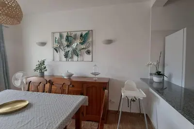 a kitchen with a table with chairs and a picture on the wall at 3 bedroom Beach House in Luz in Luz