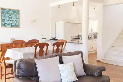 a living room with a couch and a table and a kitchen at 3 bedroom Beach House in Luz in Luz