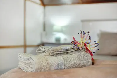 a stack of towels on a table with a flower on it at Luci's House in São Jorge