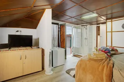 a living room with a couch and a tv in a room at Luci's House in São Jorge