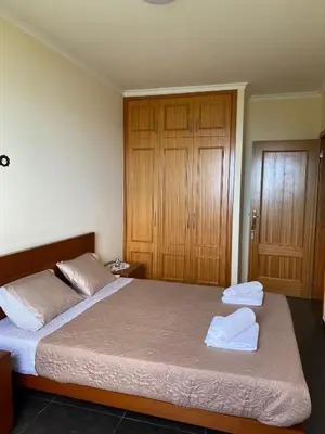 a bedroom with a bed with two towels on it at Ocean Guest House in São Vicente