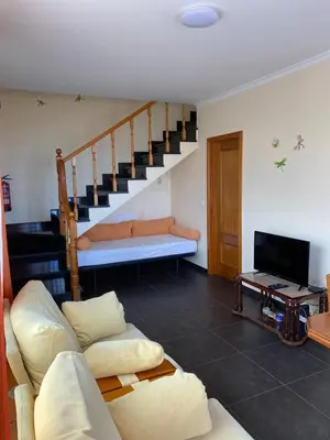 a living room with a couch and a staircase at Ocean Guest House in São Vicente