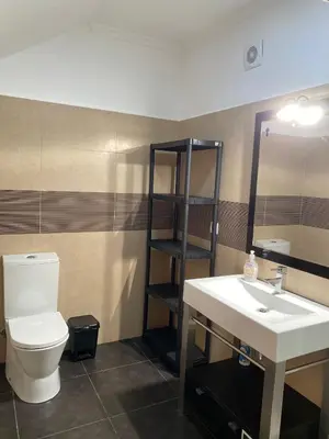 a bathroom with a sink and a toilet and a mirror at Ocean Guest House in São Vicente