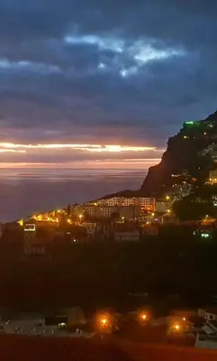 a view of a city at night with a mountain at Paraíso Pico da Torre in Câmara de Lobos