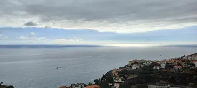 an aerial view of the ocean with houses on a hill at Paraíso Pico da Torre in Câmara de Lobos