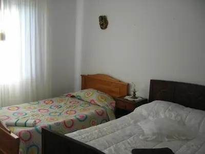 a bedroom with two beds and a window at Residencia ANA Piso Um 1 in Santa Cruz