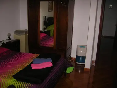 a bedroom with a mirror and a bed and a fan at Residencia ANA Piso Um 1 in Santa Cruz