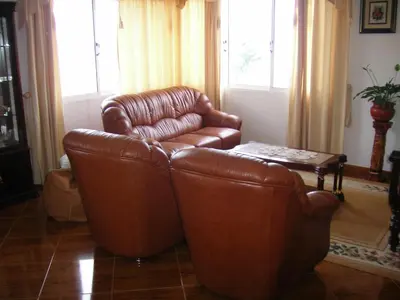 a living room with two leather chairs and a table at Residencia ANA Piso Um 1 in Santa Cruz