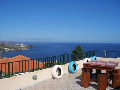 a balcony with a table and a view of the ocean at Residencia ANA Piso Um 1 in Santa Cruz