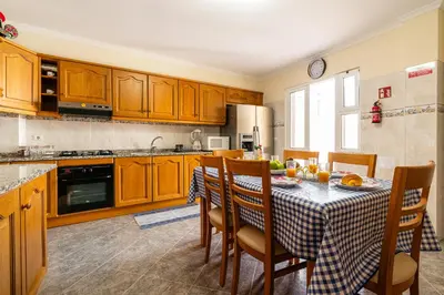 a kitchen with a table with chairs and a tablecloth on it at Vila do Conde Nº1 in Ribeira Brava