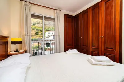 a bedroom with a large white bed with a window at Vila do Conde Nº1 in Ribeira Brava