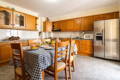 a kitchen with a table and a refrigerator at Vila do Conde Nº1 in Ribeira Brava