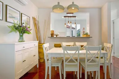 a dining room with a white table and chairs at Casa do Loureiro in Funchal