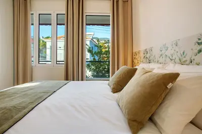 a bedroom with a large white bed with a window at Casa do Loureiro in Funchal