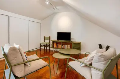 a living room with chairs and a table and a tv at Casa do Loureiro in Funchal