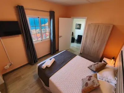 a bedroom with a large bed with blue pillows at O Cantinho do André in Porto Moniz