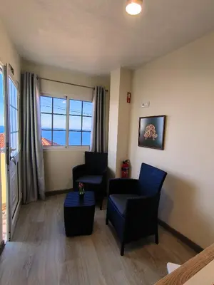 a living room with two chairs and a table at O Cantinho do André in Porto Moniz