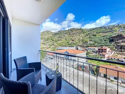 a kitchen with a washing machine and a table at Agostinho Apartment by Atlantic Holiday in Santa Cruz