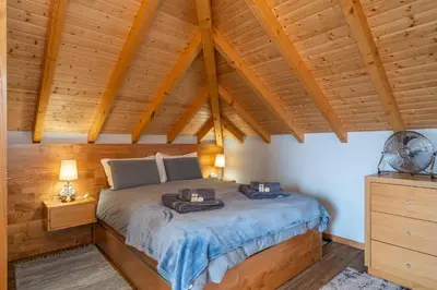 a bedroom with a bed and a wooden ceiling at Salsa Country House I in Porto Moniz