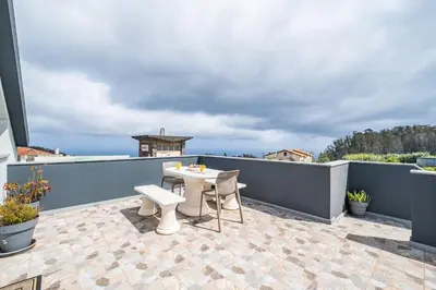 a patio with a table and chairs on a balcony at Salsa Country House I in Porto Moniz