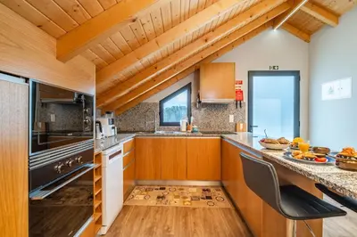 a kitchen with wooden cabinets and a counter top at Salsa Country House I in Porto Moniz