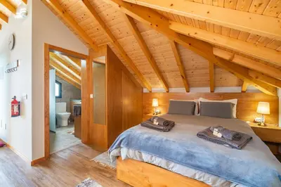 a bedroom with a large bed in a wooden house at Salsa Country House I in Porto Moniz
